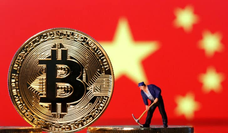 FILE PHOTO: Picture illustration of a small toy figurine and representations of the Bitcoin virtual currency displayed in front of an image of China’s flag
