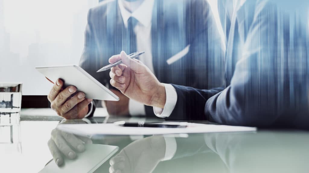 Corporate businessmen working on tablet at office การลงทุนแบบ Ray Dalio ผู้จัดการมือทองของ Hedge Fund