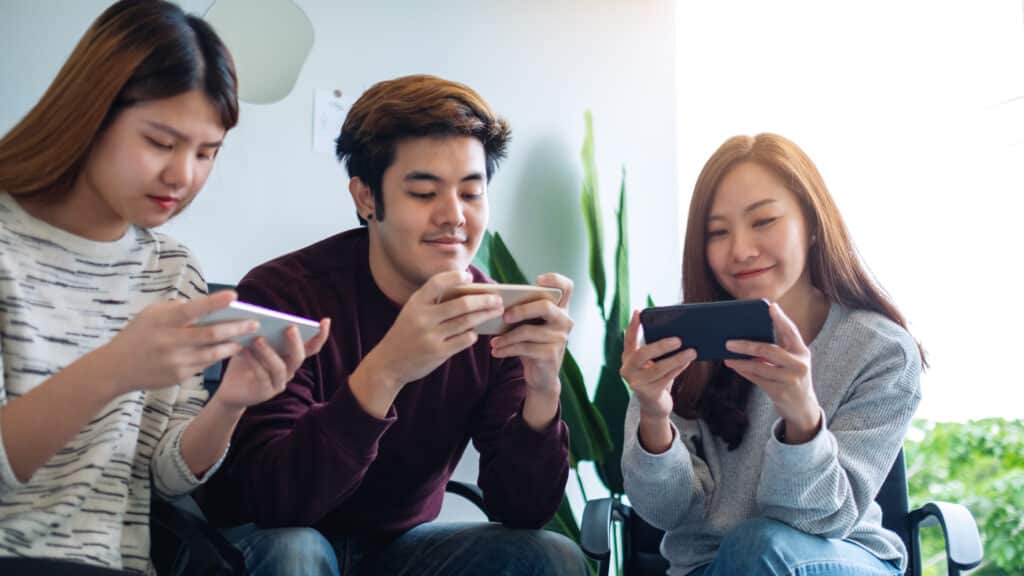 Group of young people using and playing games on mobile phone wh ไม่ฝักใฝ่หาความรู้ใหม่ๆ