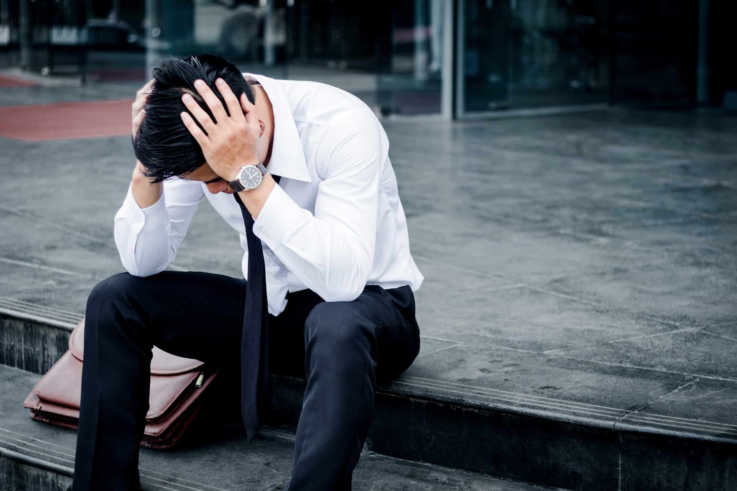 Unemployed Tired or stressed businessman sitting on the walkway ตัวเลขว่างงานบ่งชี้เศรษฐกิจได้ (Unemployment Claims)