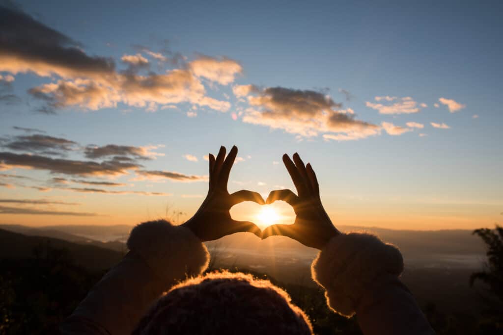 Silhouette hands forming a heart shape with sunrise วางแผนการเงิน สำหรับคนโสด